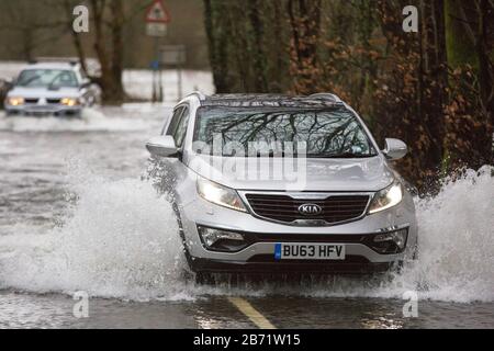 Überschwemmungen durch Storm Ciara an der Rothay Bridge in Ambleside, Lake District, Großbritannien, mit Autos durch die Überschwemmungen. Stockfoto