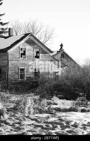 Schwarz-Weiß-Bild eines alten verlassenen Hauses und einer Scheune in Wisconsin während des Winters, senkrecht Stockfoto