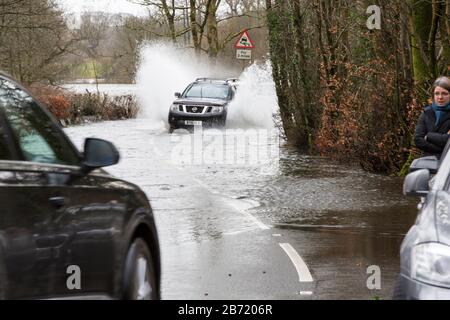 Überschwemmungen durch Storm Ciara an der Rothay Bridge in Ambleside, Lake District, Großbritannien, mit Autos durch die Überschwemmungen. Stockfoto