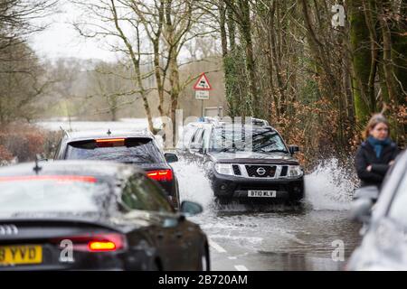 Überschwemmungen durch Storm Ciara an der Rothay Bridge in Ambleside, Lake District, Großbritannien, mit Autos durch die Überschwemmungen. Stockfoto