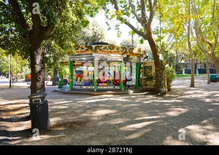 Ein Vater wartet auf sein Kind im Karussell der Villa Borghese in den Gärten der Borghese in Rom, Italien Stockfoto