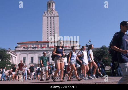 Austin, Texas USA: Studenten gehen auf dem Campus der University of Texas mit dem Hauptgebäude und dem UT-Turm im Hintergrund. ©Bob Daemmrich Stockfoto