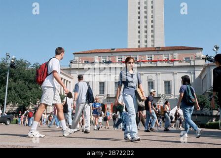 Austin, Texas USA: Studenten gehen auf dem Campus der University of Texas mit dem Hauptgebäude und dem UT-Turm im Hintergrund. ©Bob Daemmrich Stockfoto