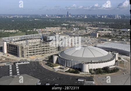 Houston, Texas, USA, August 2001: Luftaufnahme des Houston Astrodome, erbaut 1964, mit einem neuen Fußballstadion, um es im Hintergrund zu ersetzen. ©Bob Daemmrich Stockfoto