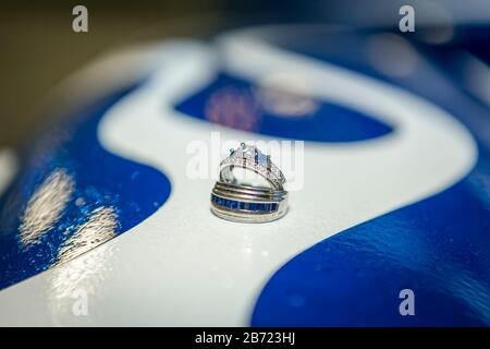 Blaustein weiß Gold seine und seine Hochzeitsbänder auf einer blau-weißen Oberfläche Stockfoto