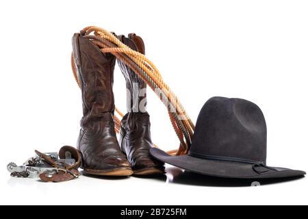 Westliche Stiefel und ein Runde- oder Lariatseil und Sporen und ein Cowboyhut auf weißem Hintergrund Stockfoto