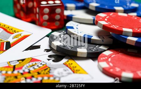 Pokerchips, Spielkarten und Würfel auf einem grünen Backgrorund. Glücksspiel Stockfoto