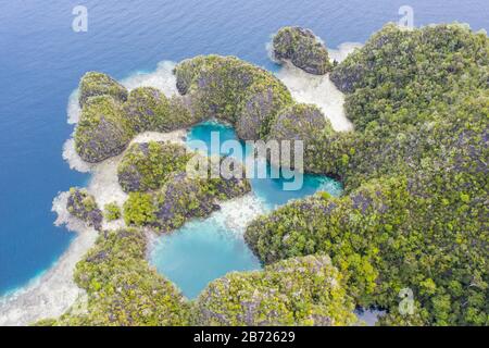 Die schönen Felseninseln in Raja Ampat, Indonesien, sind uralte Korallenriffe, die vor Millionen von Jahren durch tektonische Ereignisse aufgewälzt wurden. Stockfoto