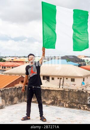 Stolz Nigeria. Foto eines jungen Afrika-Mannes, der seine Flagge hält und sagt, ich bin stolz darauf, ein Nigerianer, die Bundesrepublik Nigeria zu sein Stockfoto