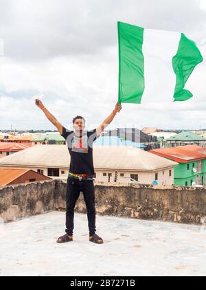 Stolz Nigeria. Foto eines jungen Afrika-Mannes, der seine Flagge hält und sagt, ich bin stolz darauf, ein Nigerianer, die Bundesrepublik Nigeria zu sein Stockfoto