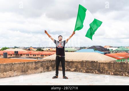 Stolz Nigeria. Foto eines jungen Afrika-Mannes, der seine Flagge hält und sagt, ich bin stolz darauf, ein Nigerianer, die Bundesrepublik Nigeria zu sein Stockfoto