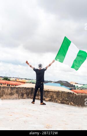 Stolz Nigeria. Foto eines jungen Afrika-Mannes, der seine Flagge hält und sagt, ich bin stolz darauf, ein Nigerianer, die Bundesrepublik Nigeria zu sein Stockfoto