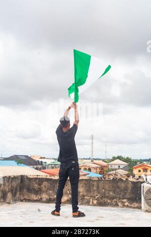 Stolz Nigeria. Foto eines jungen Afrika-Mannes, der seine Flagge hält und sagt, ich bin stolz darauf, ein Nigerianer, die Bundesrepublik Nigeria zu sein Stockfoto