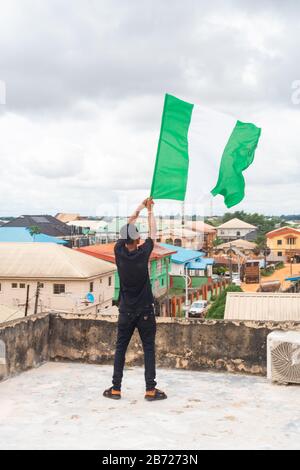 Stolz Nigeria. Foto eines jungen Afrika-Mannes, der seine Flagge hält und sagt, ich bin stolz darauf, ein Nigerianer, die Bundesrepublik Nigeria zu sein Stockfoto