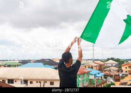 Stolz Nigeria. Foto eines jungen Afrika-Mannes, der seine Flagge hält und sagt, ich bin stolz darauf, ein Nigerianer, die Bundesrepublik Nigeria zu sein Stockfoto