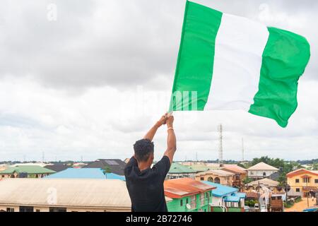 Stolz Nigeria. Foto eines jungen Afrika-Mannes, der seine Flagge hält und sagt, ich bin stolz darauf, ein Nigerianer, die Bundesrepublik Nigeria zu sein Stockfoto