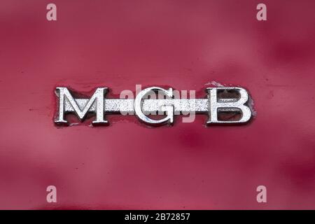 Detail von glänzendem Chrom "MGB" Bar Abzeichen auf dem hinteren Boot des klassischen roten britischen MG MGB Sportwagen bei der Auto-Rallye in Oxfordshire, Großbritannien angezeigt. Stockfoto