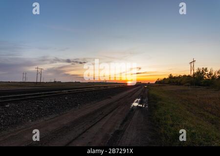 Ein wunderschöner Herbstuntergang an den Bahngleisen in Saskatchewan, Kanada Stockfoto