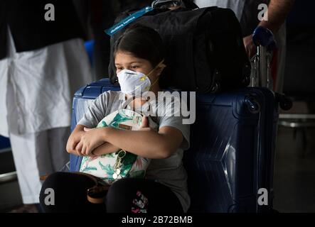 Peking, Indien. März 2020. Ein Mädchen, das Maske trägt, ist am Indra Gandhi International Airport in Neu-Delhi, Indien, am 12. März 2020 zu sehen. Die indische Regierung hat alle Touristenvisa im Rahmen der COVID-19-Verbreitung ausgesetzt. Laut dem Update der indischen Regierung am Donnerstagnachmittag gab es landesweit 74 bestätigte Fälle von Coronavirus. Credit: Javed Dar/Xinhua/Alamy Live News Stockfoto