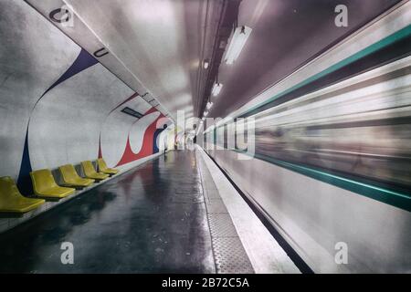 Ein fahrender Zug, der einen leeren Bahnsteig an der U-Bahn-Station Assemblee-Nationale, Paris, Frankreich, Europa, Farbe verlässt Stockfoto