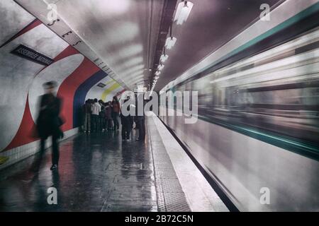 Ein abfahrender Zug in Bewegung, während die Passagiere zur Bahnsteigausfahrt an der U-Bahn-Station Assemblee-Nationale, Paris, Frankreich, Europa, Farbe laufen Stockfoto