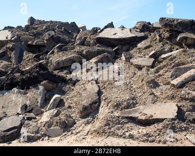 Berg aus Asphalt und Betonboden, Parklott-Trümmer, Trümmerhaufen, Straßenabbaustelle, riesige Abschnitte aus Beton, Asphalt, Kies und Sand Stockfoto