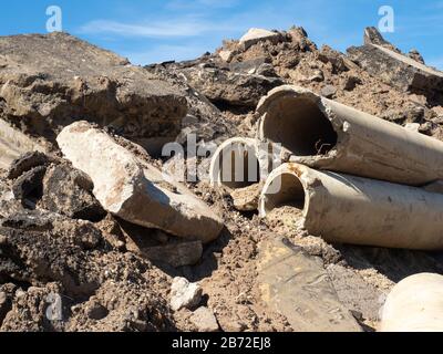 Straßenabbauschutt, Straßenschutt, Betonkanalisationsrohre, Abschnitte aus Beton- und Asphaltpflaster, Straßenbett, zerbrochener Asphalt Ansicht #2 näher betrachtet Stockfoto