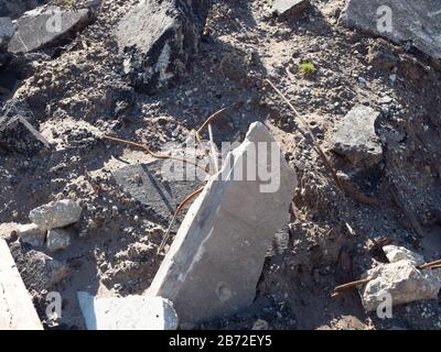 Trümmerschutt auf der Straße, Nahaufnahme von Trümmern, Brocken von Beton und Asphaltpflaster, Metallrohre aus zerbrochenen Betonblöcken Stockfoto