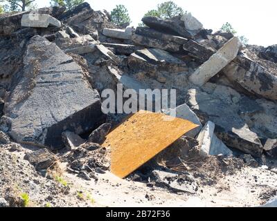 Massiver Haufen von Straßenschutt, Straßenabbauschutt, Abbruchstelle mit riesigen Abschnitten aus Betonpflaster, Asphalt, Aufkantung und Metallplatte Stockfoto