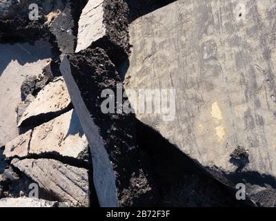 Riesige Straßenabschnitte, abgerissene Straßenschutt, Asphaltrückstände, Straßenbelag, Querschnitt durch Asphalt Nahansicht Stockfoto