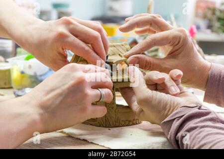 Im Klassenzimmer Keramik. Schüler sculpt aus Ton, der Lehrer hilft Stockfoto