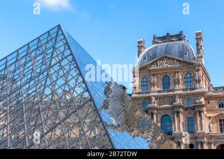 Frankreich. Sonniger Tag in Paris. Das Gebäude des Louvre spiegelt sich in den Gesichtern der Glaspyramide wider Stockfoto