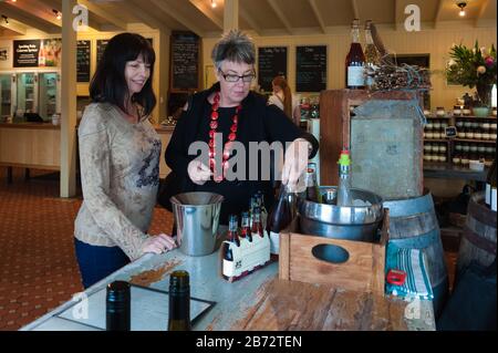 Zwei weibliche Touristen im Bauernhaus auf der Farm von Maggie Beer im Barossa-Tal in South Australia bereiten sich auf den Geschmack der Weine vor. Stockfoto