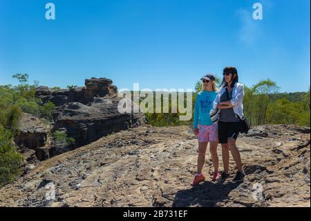 Zwei Spaziergänger machen eine Pause, um den Blick auf die Cobbold Gorge während ihres Trecks im Resort Western Queensland zu bewundern. Stockfoto