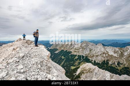 Wanderer auf dem Gipfel der östlichen Oedkarspitze, Blick auf das Karwendeltal, Hinterautal-Vomper-Kette, Karwendel, Tyrol, Österreich Stockfoto