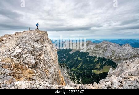 Wanderer auf dem Gipfel der östlichen Oedkarspitze, Blick auf das Karwendeltal, Hinterautal-Vomper-Kette, Karwendel, Tyrol, Österreich Stockfoto