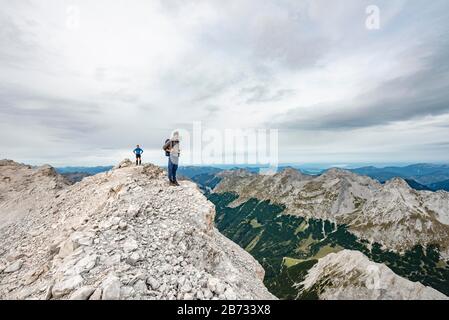 Wanderer auf dem Gipfel der östlichen Oedkarspitze, Blick auf das Karwendeltal, Hinterautal-Vomper-Kette, Karwendel, Tyrol, Österreich Stockfoto