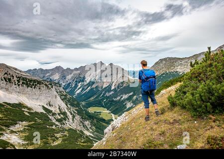 Wanderer blickt in das Karwendeltal mit Raffelspitze und Hochkarspitze, Wanderweg zur Birkkarspitze, Vomper-Kette, Karwendel, Tyrol, Österreich Stockfoto