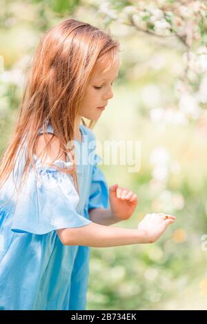 Entzückende kleine Mädchen in blühender Apfelgarten an schönen Frühlingstag Stockfoto