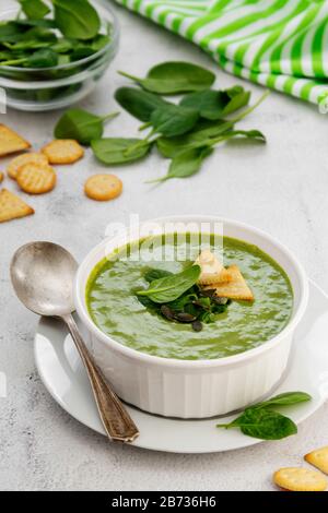Cremig grüne Spinatsuppe in einer weißen Schüssel, Frühling gesunde grüne cremige Suppe. Entgiften, nähren oder reinigen Sie Lebensmittel Stockfoto