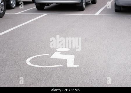 Parkplatzkennzeichnung für Behinderte auf der Asphaltstraße. Verkehrssymbol auf der Straße. Stockfoto