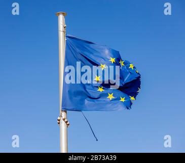 Europa - zerrissene europäische Flagge flattert im Wind am Fahnenmast, symbolisches Bild von EUROPA IN DER KRISE. Europa - Zerrissene Europafahne schmeichelt am Fahn Stockfoto