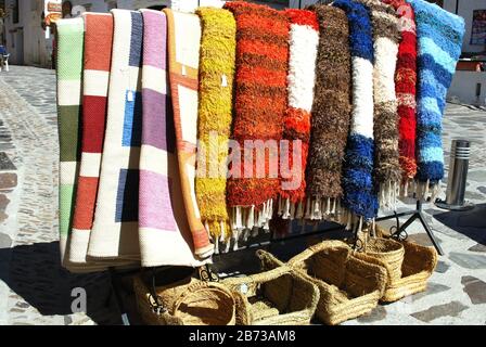 Vor Ort hergestellte Teppiche zum Verkauf vor einem Dorf Handwerk und Souvenirladen, Pampaneira, Spanien, Europa. Stockfoto