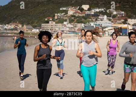 Vorderansicht der Frauen, die am Strand laufen Stockfoto