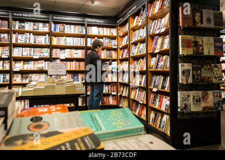Ein Kunde, der in einem Waterstones Book Shop Book Store stöbere. Stockfoto