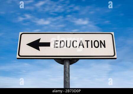 Bildung Verkehrsschild, Pfeil auf blauen Himmel Hintergrund. Ein Weg leeren Straßenschild mit Kopie Platz. Pfeil auf einer Stange, die in eine Richtung zeigt. Stockfoto