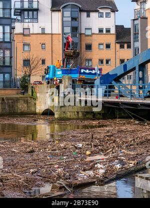 The Shore, Leith, Edinburgh, Schottland, Großbritannien. März 2020. Wasser von Leith aufräumen: Häufiger starker Regen in den letzten Monaten verursacht an der alten Victoria-Drehbrücke an der Flussmünde am Ausgang zu Leith Docks einen ständigen Abfall- und Schuttaufbau. Es ist ein Hingucker und eine Gefahr für Tiere, bis eine Einigung zwischen der Stadtverwaltung von Edinburgh, Water of Leith Conservation Trust & Forth Ports für ein Instandhaltungsprogramm erzielt wurde, aber die Arbeiten müssen in regelmäßigen Abständen durchgeführt werden, nachdem sie zuletzt im Dezember durchgeführt wurden Stockfoto