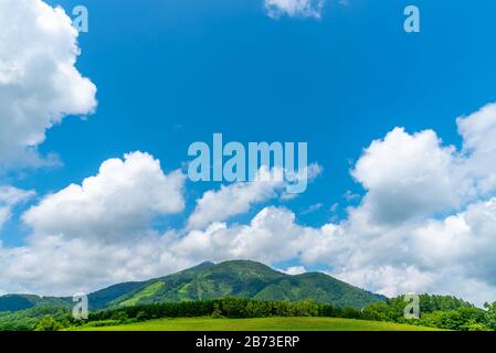 Mt. Niseko-Annupuri im Frühling sonniger Tag. Ländliche Naturlandschaften, blauer Himmel und weiße Wolken im Hintergrund. Stadt Niseko, Unterpräfektu Shiribeshi, Stockfoto