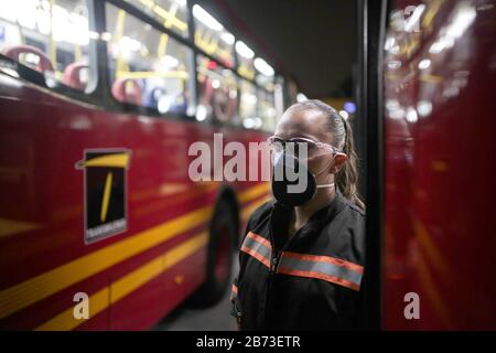 (200313) -- BOGOTA, 13. März 2020 (Xinhua) -- Eine Mitarbeiterin trägt eine Gesichtsmaske, während sie einen Bus in Bogota, der Hauptstadt Kolumbiens, am 11. März 2020 reinigt. Der kolumbianische Präsident Ivan Duque hat einen landesweiten Gesundheitsnotstand ausgerufen, der jegliche Aktivitäten von mehr als 500 Menschen untersagt, und infolgedessen wurde die diesjährige Internationale Buchmesse von Bogota auf einen späteren Zeitpunkt verschoben. (Xinhua/Jhon Paz) Stockfoto