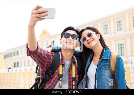 Portrait des jungen, glücklichen asiatischen Touristenpaares in legerer Kleidung, die während der Reise in Bangkok Thailand selfie mitnimmt Stockfoto